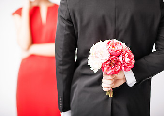 Image showing man hiding bouquet of flowers