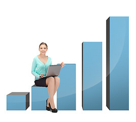 Image showing businesswoman sitting on big 3d chart