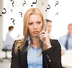 Image showing confused woman with phone in office