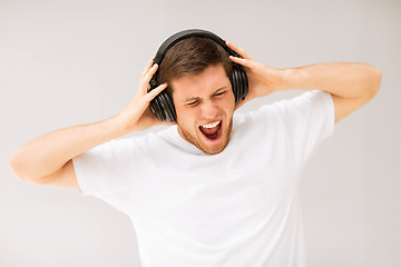 Image showing man with headphones listening loud music