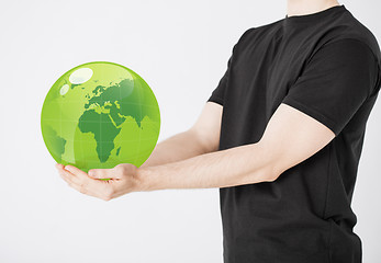 Image showing man holding green sphere globe