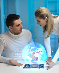 Image showing futuristic man and woman with globe hologram