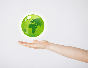 Image showing mans hand holding green globe