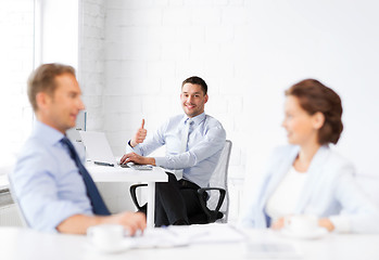 Image showing happy businessman showing thumbs up in office