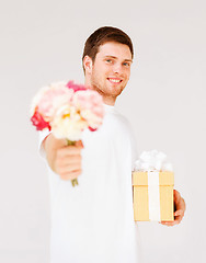 Image showing man holding bouquet of flowers and gift box