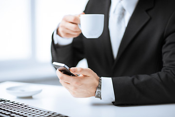 Image showing man hands with keyboard, smartphone and coffee