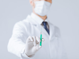 Image showing male doctor holding syringe with injection