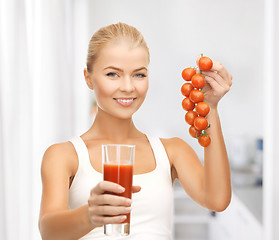 Image showing woman holding glass of juice and tomatoes