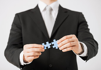 Image showing man trying to connect puzzle pieces