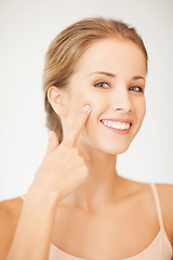 Image showing woman pointing at her cheek