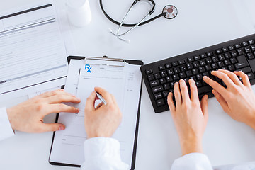 Image showing doctor and nurse writing prescription paper