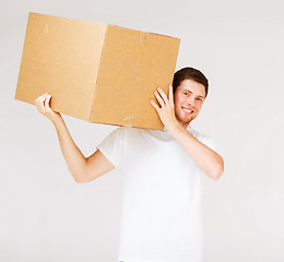 Image showing smiling man carrying carton box