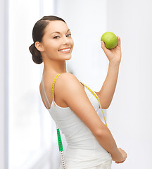 Image showing sporty woman with apple and measuring tape