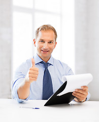 Image showing businessman with papers showing thumbs up