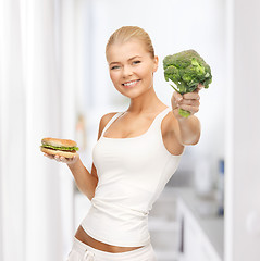 Image showing woman with broccoli and hamburger