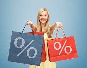 Image showing woman holding shopping bags with percent sign