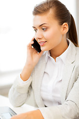 Image showing businesswoman with smartphone in office