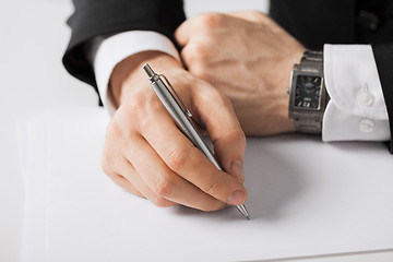 Image showing businessman writing something on the paper