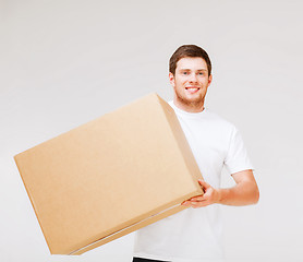 Image showing smiling man carrying carton box