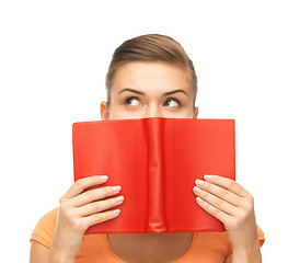 Image showing woman eyes and hands holding red book