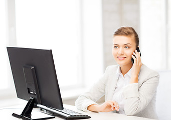 Image showing businesswoman with smartphone in office