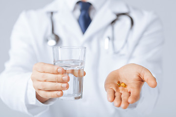 Image showing doctor hands giving capsule and glass of water