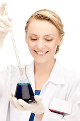 Image showing female chemist holding bulb with chemicals