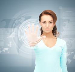 Image showing businesswoman touching virtual screen