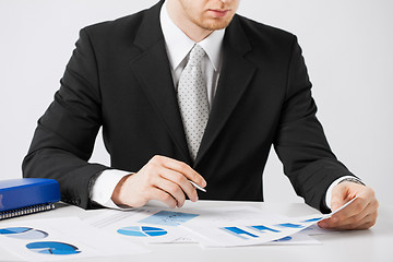Image showing businessman working and signing with papers