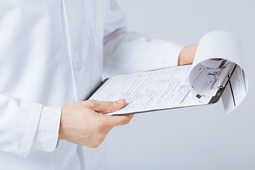 Image showing male doctor holding prescription paper in hand