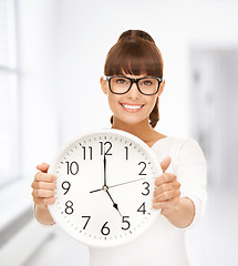 Image showing businesswoman with wall clock