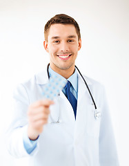 Image showing young male doctor with pack of pills