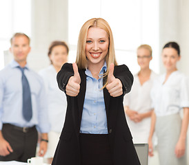 Image showing businesswoman with thumbs up in office