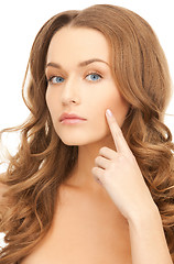 Image showing woman pointing at her cheek