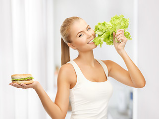Image showing woman with green lettuce and hamburger