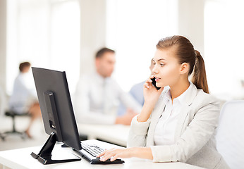 Image showing businesswoman with smartphone in office