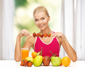 Image showing woman with organic food eating strawberry