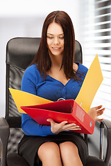 Image showing young businesswoman with folders sitting in chair