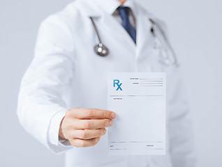 Image showing male doctor holding rx paper in hand