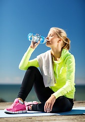 Image showing woman drinking water after doing sports outdoors