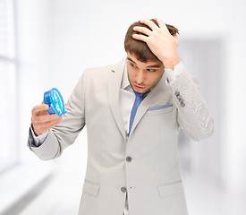 Image showing handsome businessman looking at alarm clock