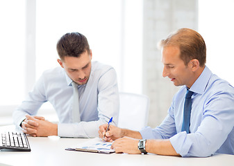 Image showing businessmen with notebook on meeting