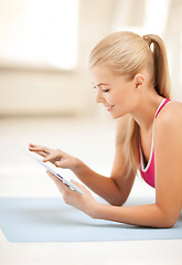 Image showing woman lying on the floor with tablet pc