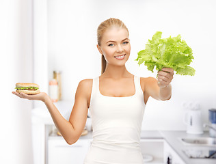 Image showing woman with green leaves and hamburger