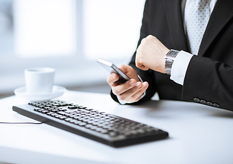 Image showing man hands with keyboard, smartphone and wristwatch