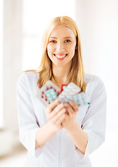 Image showing young female doctor with pack of pills