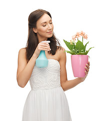 Image showing woman holding pot with flower and spray bottle