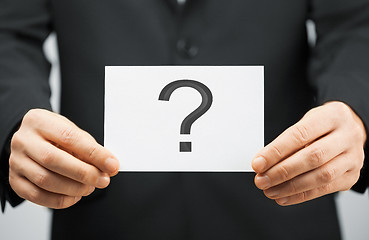 Image showing man in suit holding card with question mark