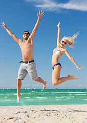 Image showing couple jumping on the beach