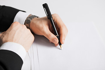 Image showing businessman writing something on the paper